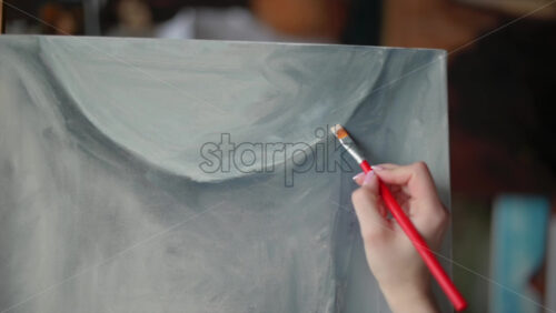 Video - Woman painter wearing black clothes painting woman model at a workshop