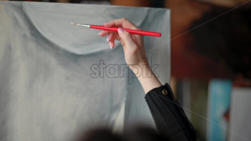 Video - Woman painter wearing black clothes painting woman model at a workshop
