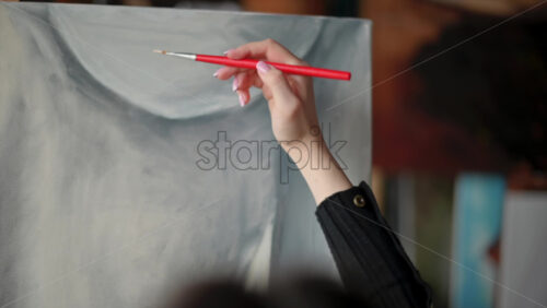 Video - Woman painter wearing black clothes painting woman model at a workshop