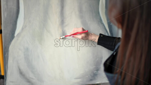 Video - Woman painter wearing black clothes painting woman model at a workshop