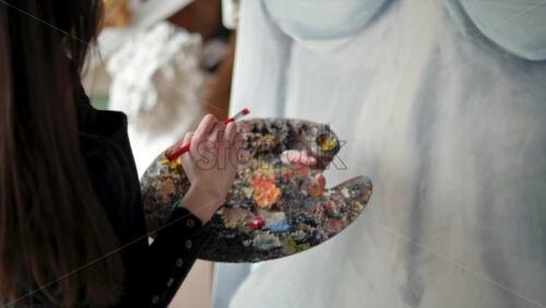 Video - Woman painting a female body on a canvas at an art gallery workshop