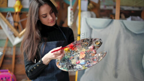 Video - Woman painting a female body on a canvas at an art gallery workshop