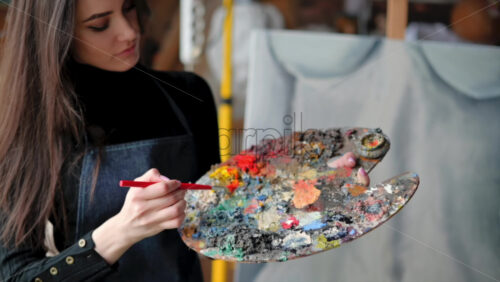 Video - Woman painter wearing black clothes painting woman model at a workshop