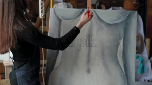 Video - Woman painting a female body on a canvas at an art gallery workshop