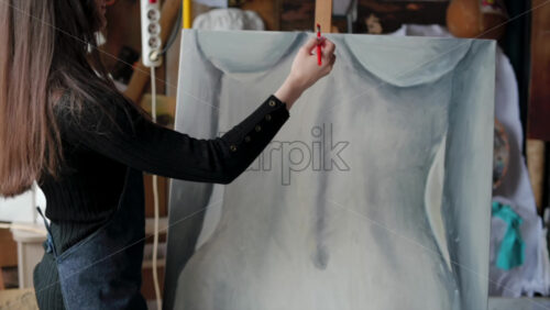 Video - Woman painter wearing black clothes painting woman model at a workshop