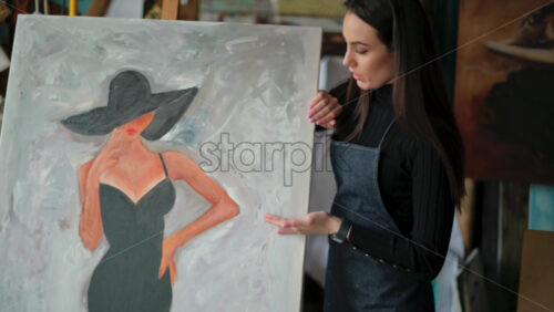 Video - Woman presenting a painting at an art gallery workshop