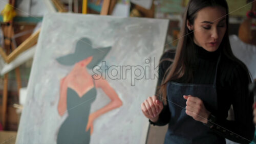 Video - Woman presenting a painting at an art gallery workshop