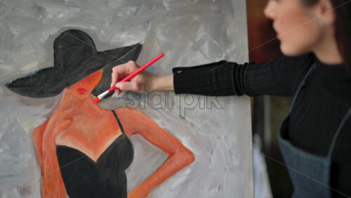 Video - Woman painting a female on a canvas at an art gallery workshop
