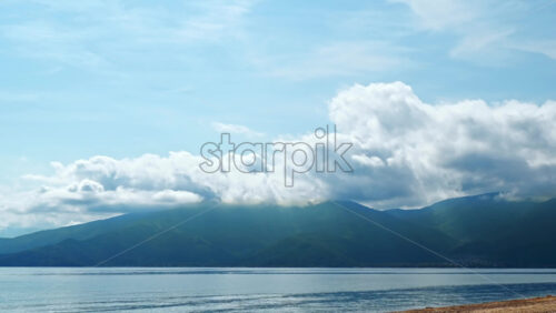 Video - Hyperlapse of the Aegean sea and a mountain visible in the distance, moving clouds in Greece