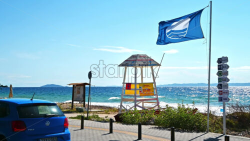 Video - NIKITI, GREECE - OCTOBER 8, 2020: Aegean sea coast with sign post, flag and first aid tower
