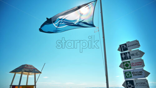 Video - NIKITI, GREECE - OCTOBER 8, 2020: Aegean sea coast with sign post, flag and first aid tower
