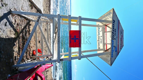 Video - NIKITI, GREECE - OCTOBER 8, 2020: First aid tower with boat and life ring near it, Aegean sea on the background. Vertical shooting