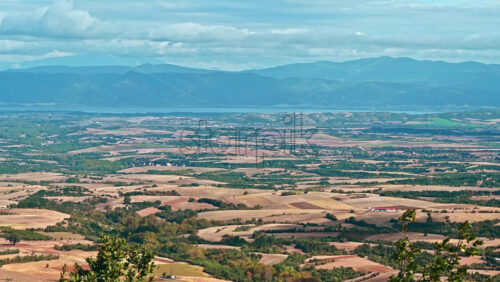 Video - Nature scape of Greece, fields with greenery, green hills visible in the distance, cloudy weather