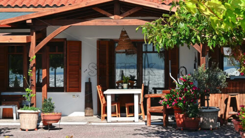 Video - Front yard and terrace of an restaurant made in national style with greenery, chairs ad tables in Nikiti, Greece