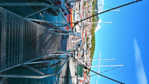 Video - NEOS MARMARAS, GREECE - OCTOBER 8, 2020: Aegean sea port with multiple moored yachts and boats, wooden pier, town located on a hill with greenery, clear weather