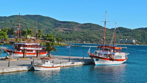 Video - NEOS MARMARAS, GREECE - OCTOBER 8, 2020: Moored sailboat near a pier, green hill on the background. Slow motion
