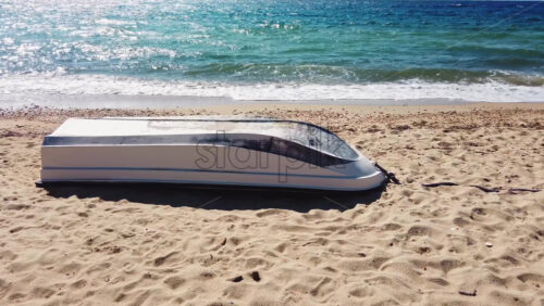 Video - Flipped boat on a beach, waves of the Aegean sea in Nikiti, Greece