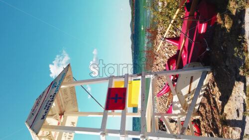 Video - NIKITI, GREECE - OCTOBER 8, 2020: First aid tower with boat and life ring near it, Aegean sea on the background. Vertical shooting, slow motion