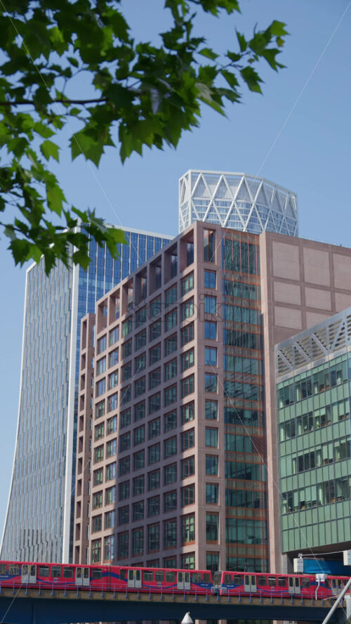 A Railway moving through Canary Wharf. Vertical, London, England - Starpik Stock