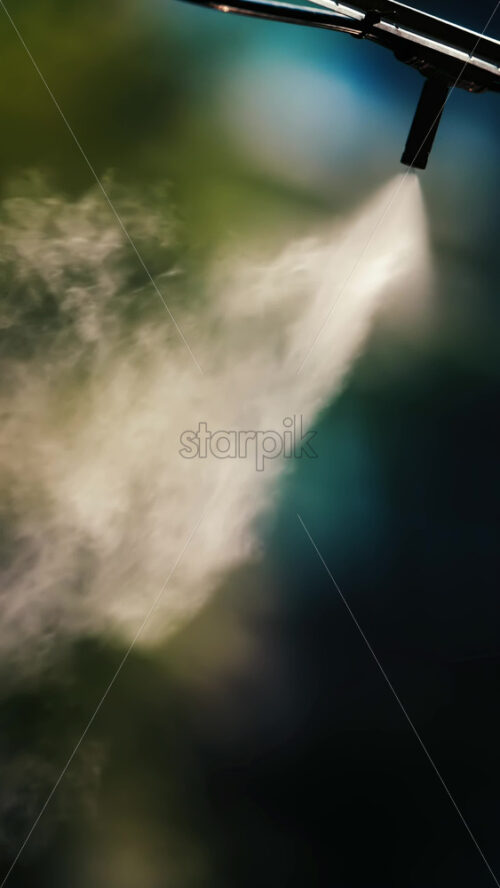 A jet of water spraying into the air against a dark background - Starpik Stock
