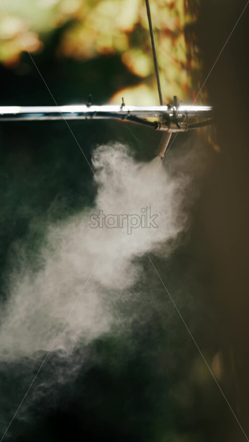 A jet of water spraying into the air against a dark background - Starpik Stock