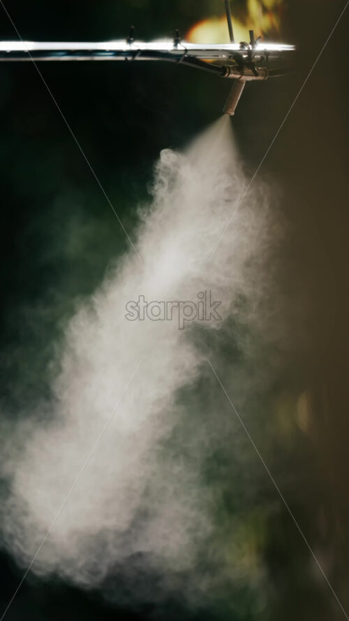 A jet of water spraying into the air against a dark background - Starpik Stock