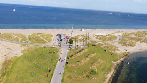Aerial drone view of Amager Strandpark beach and promenade, with people sunbathing and walking along the pier - Starpik Stock