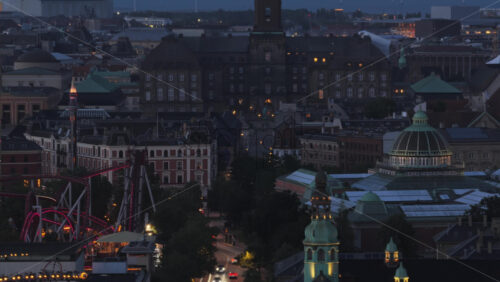Aerial drone view of Copenhagen City Hall lit up at night with Tivoli Gardens amusement park in the background in Denmark - Starpik Stock