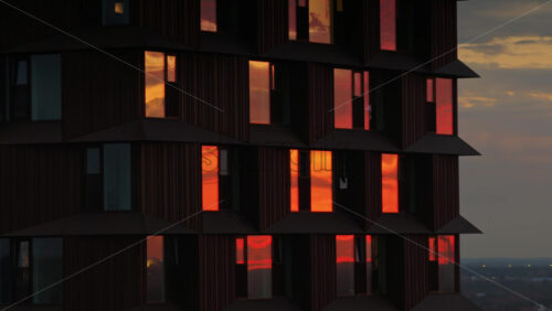 Aerial drone view of Copenhagen’s Domus Vista skyscraper with fiery sunset reflections in its windows - Starpik Stock
