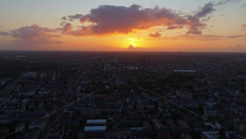 Aerial drone view of Copenhagen’s skyline at golden hour, with vibrant clouds above the city and warm sunlight illuminating the horizon - Starpik Stock