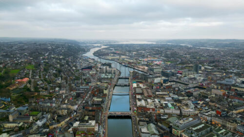 Aerial drone view of Cork City, Ireland, with the River Lee winding through the city center and multiple bridges connecting both sides - Starpik Stock
