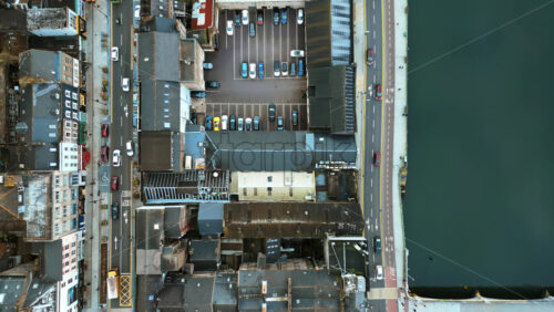 Aerial drone view of Cork’s River Lee and its iconic bridges flowing through the city center, with dense architecture and traffic movement - Starpik Stock