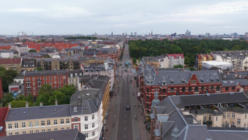 Aerial drone view of Norrebrogade, one of the busiest streets in Norrebro, Copenhagen, Denmark, looking towards the city center skyline - Starpik Stock