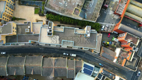 Aerial drone view of a modern urban block featuring rooftop gardens, geometric architecture, and clean streets - Starpik Stock