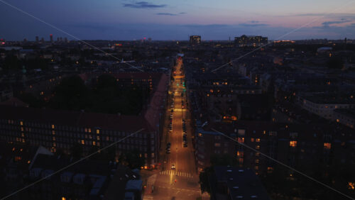 Aerial drone view of a straight city street lit up at night in Osterbro district, Copenhagen, Denmark - Starpik Stock