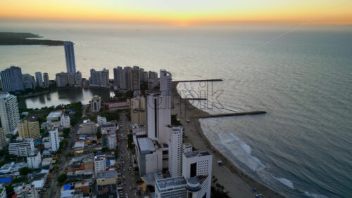 Aerial drone view of buildings alongside the Caribbean coastline in Cartagena, Colombia in the evening - Starpik Stock