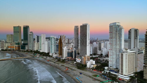 Aerial drone view of buildings alongside the Caribbean coastline in Cartagena, Colombia in the evening - Starpik Stock