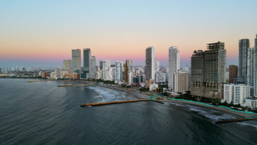 Aerial drone view of buildings alongside the Caribbean coastline in Cartagena, Colombia in the evening - Starpik Stock