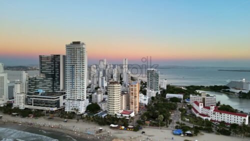 Aerial drone view of buildings alongside the Caribbean coastline in Cartagena, Colombia in the evening - Starpik Stock
