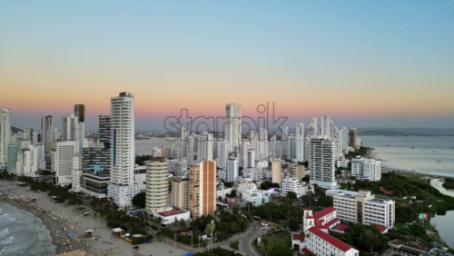 Aerial drone view of buildings alongside the Caribbean coastline in Cartagena, Colombia in the evening - Starpik Stock