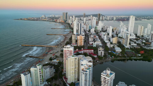 Aerial drone view of buildings alongside the Caribbean coastline in Cartagena, Colombia in the evening - Starpik Stock