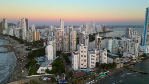 Aerial drone view of buildings alongside the Caribbean coastline in Cartagena, Colombia in the evening - Starpik Stock