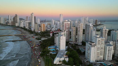 Aerial drone view of buildings alongside the Caribbean coastline in Cartagena, Colombia in the evening - Starpik Stock