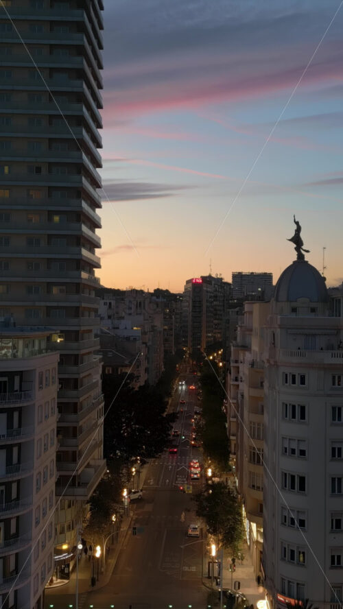 Aerial drone view of cars moving around the city at sunset in Alicante, Spain. Vertical - Starpik Stock