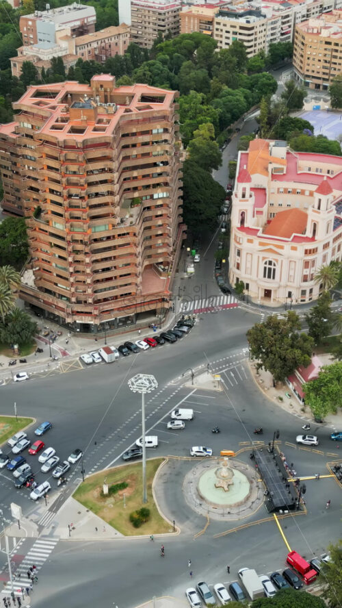 Aerial drone view of cars moving on the streets between the buildings in Valencia, Spain in daylight. Vertical - Starpik Stock