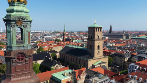 Aerial drone view of historic church towers including the spire of Nikolaj Kunsthal and the tower of Church of Our Lady in Copenhagen, Denmark - Starpik Stock