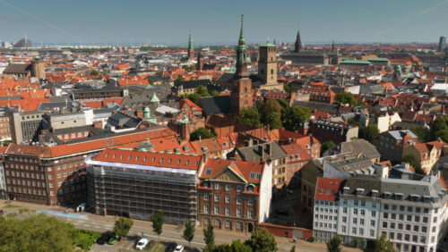 Aerial drone view of historic church towers including the spire of Nikolaj Kunsthal and the tower of Church of Our Lady in Copenhagen, Denmark - Starpik Stock