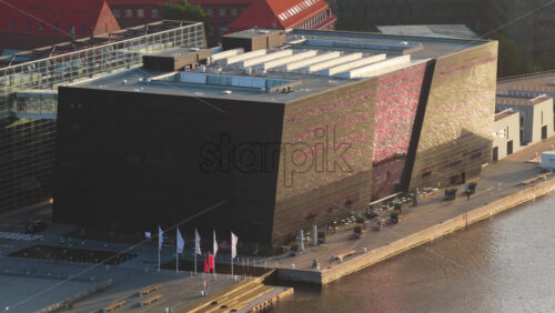 Aerial drone view of of the Black Diamond library reflecting golden light on its modern glass facade - Starpik Stock
