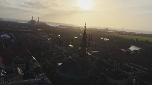 Aerial drone view of the Church of Our Saviour in Copenhagen, Denmark with wind mills on the background - Starpik Stock