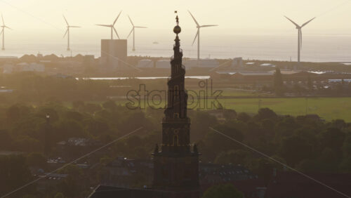 Aerial drone view of the Church of Our Saviour in Copenhagen, Denmark with wind mills on the background - Starpik Stock
